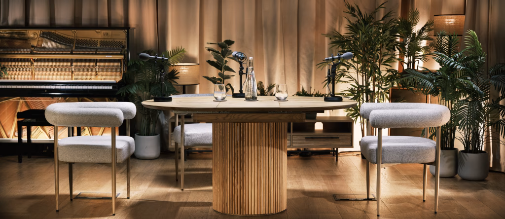 Podcast Studio A featuring an oak table and three grey chairs