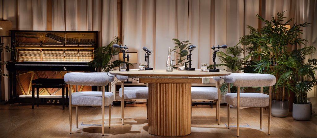 Podcast Studio A featuring an oak table and four grey chairs
